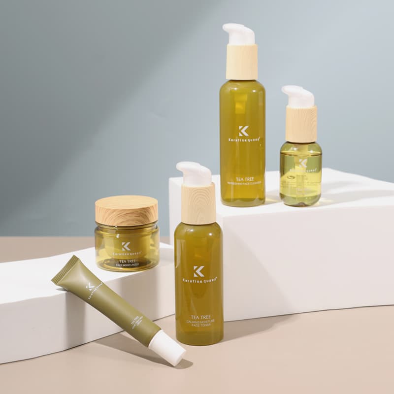 Keratine Queen tea tree skincare products with wood-textured caps arranged on white geometric blocks.